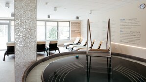 A modern indoor swimming pool with clear water, surrounded by lounge chairs and informational panels. - Hotel Termal - Sava Hotels & Resorts (Moravske Toplice)