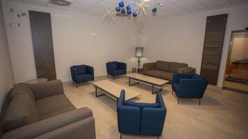 A modern waiting area with sofas, armchairs, and a coffee table.