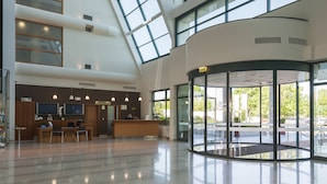 A spacious lobby with a reception desk, seating area, and large windows allowing natural light. - Hotel Livada Prestige - Sava Hotels & Resorts (Moravske Toplice)