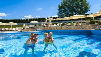 Relax by the pool surrounded by lounge chairs and umbrellas.