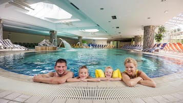 Alberca techada, alberca al aire libre y sombrillas en la alberca