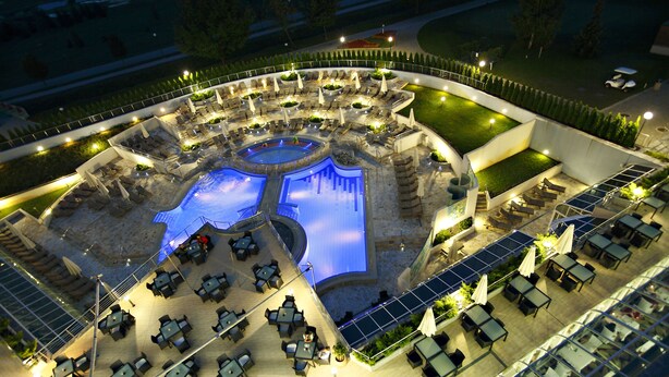 An outdoor pool area with multiple seating arrangements and a central water feature. - Hotel Livada Prestige - Sava Hotels & Resorts (Moravske Toplice)