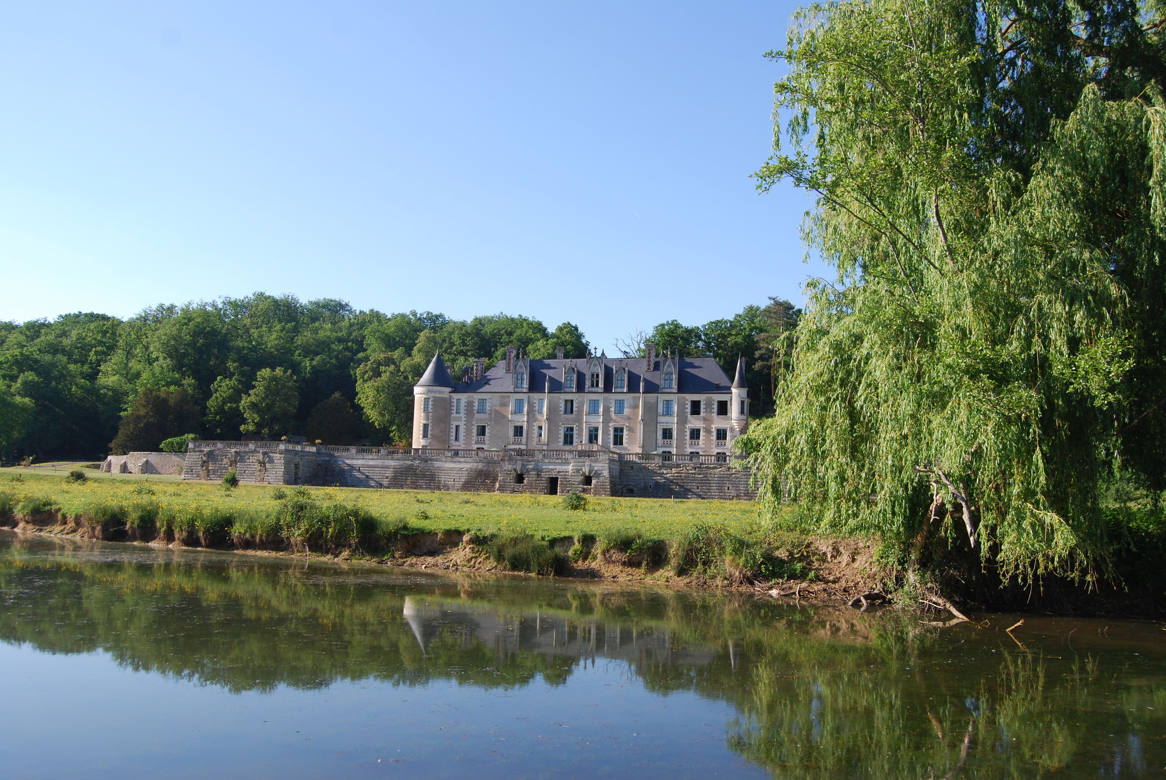 Un grand bâtiment historique doté de nombreuses tours et dont l’image se reflète dans l’eau.