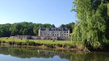 Un grand bâtiment historique doté de nombreuses tours et dont l’image se reflète dans l’eau.