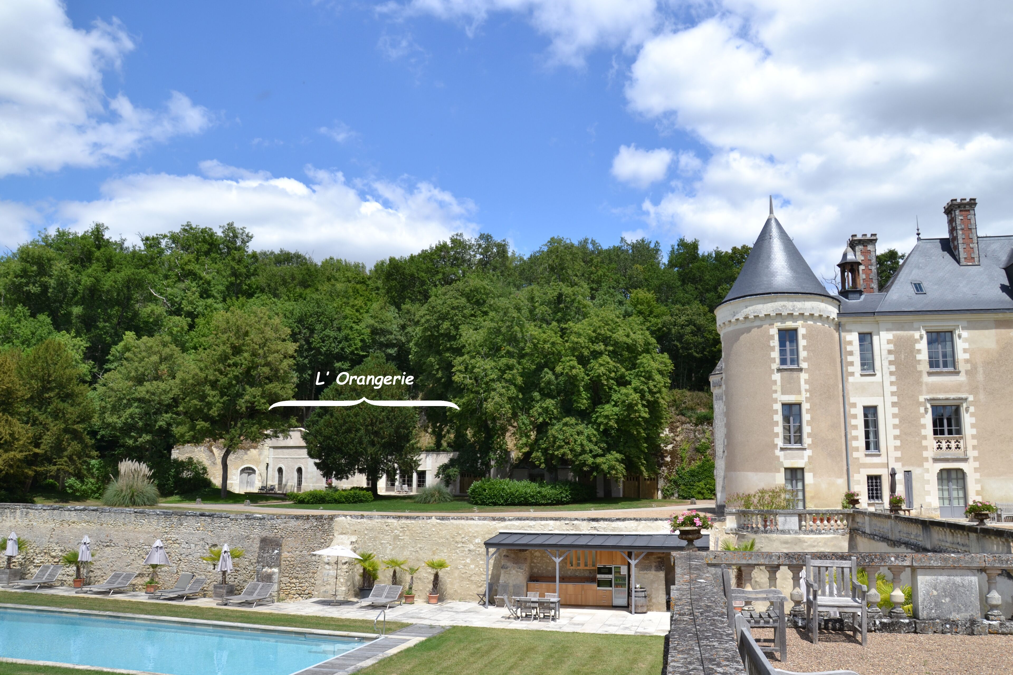 Un edificio grande e histórico con piscina y zona de estar al aire libre.