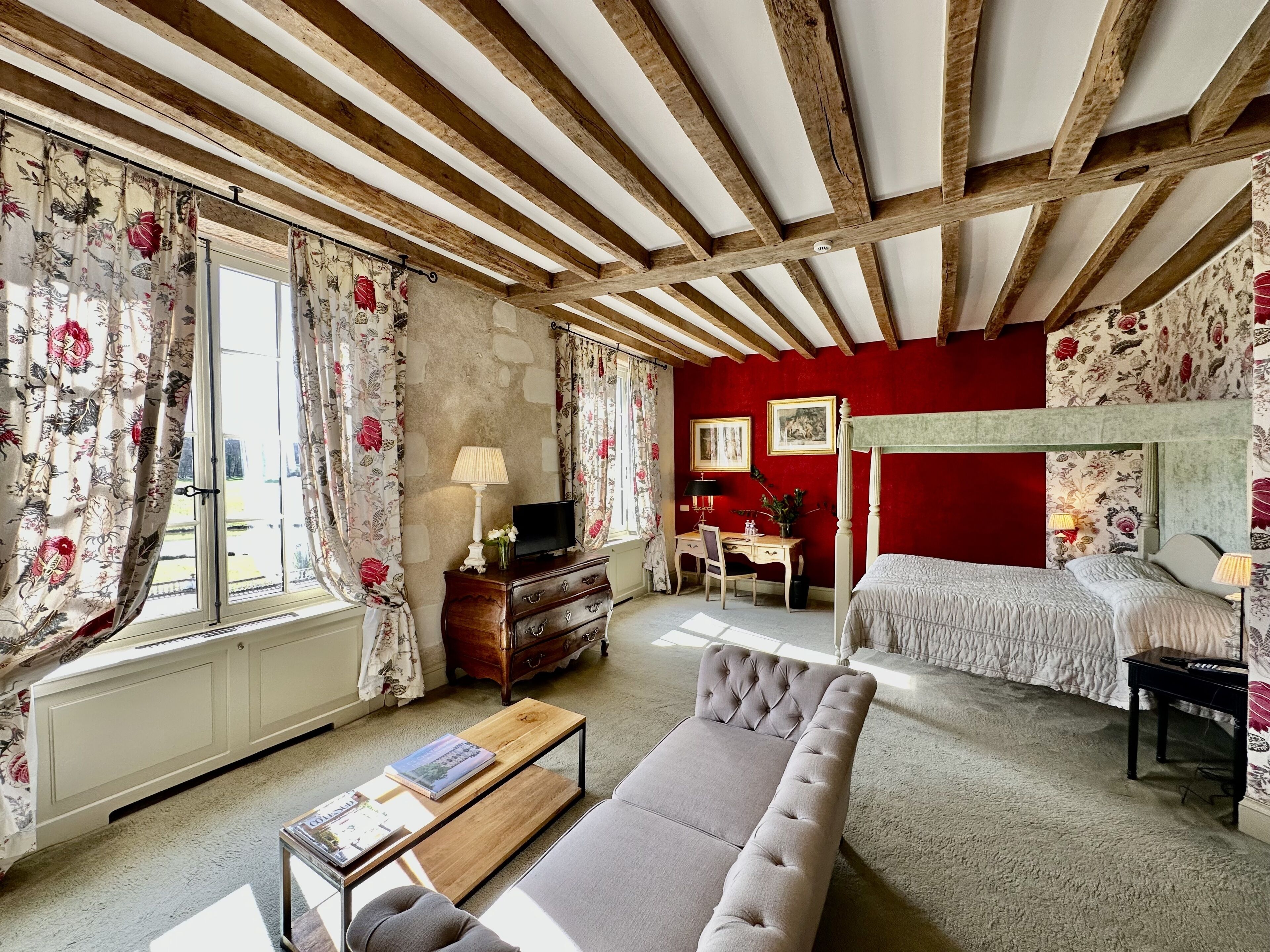 A bedroom with a bed, a sofa, a desk, and a chair.