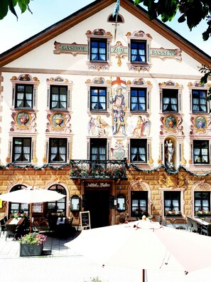 A building with ornate architectural details, including a balcony with flowers and a sign reading "Gasthof Zum Rassen". - Gasthof zum Rassen (Garmisch-Partenkirchen)