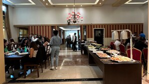 A spacious buffet area with a variety of food options, a central chandelier, and a clean, modern design. - Padova Hotel (Sin El Fil)