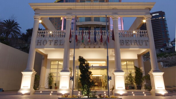 A hotel entrance with a grand facade, multiple balconies, and flags. - Padova Hotel (Sin El Fil)