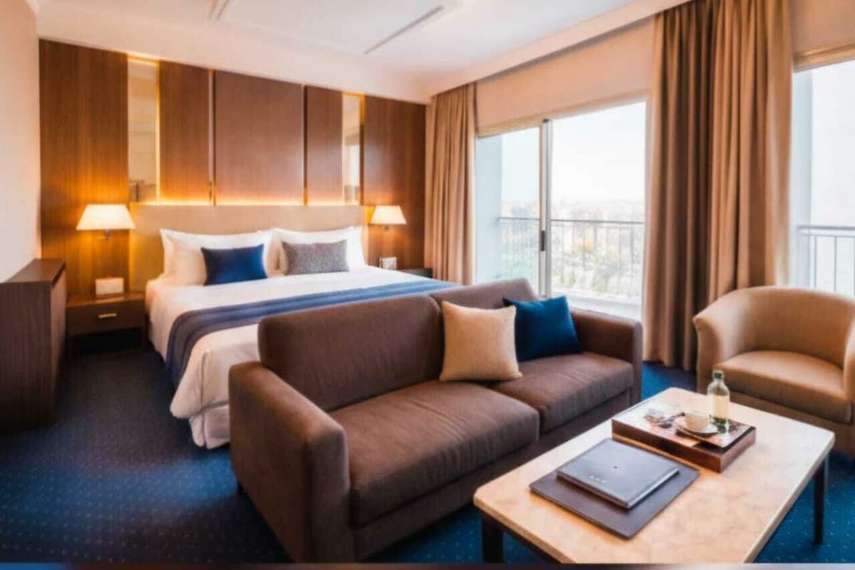 Una habitación de hotel con una cama grande, un sofá, una mesa de centro y vistas a la ciudad.