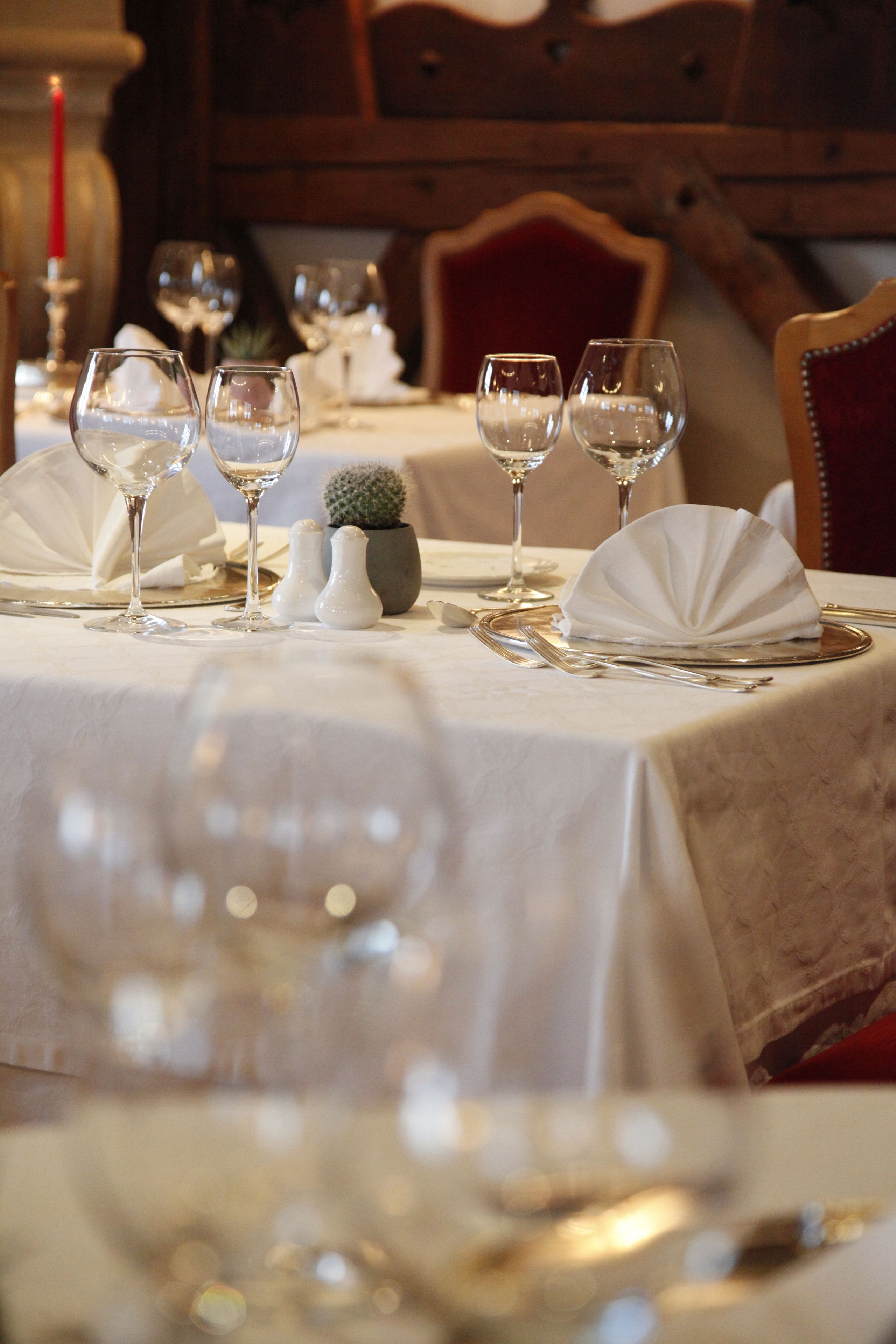 A dining table set with wine glasses, plates, and cutlery.