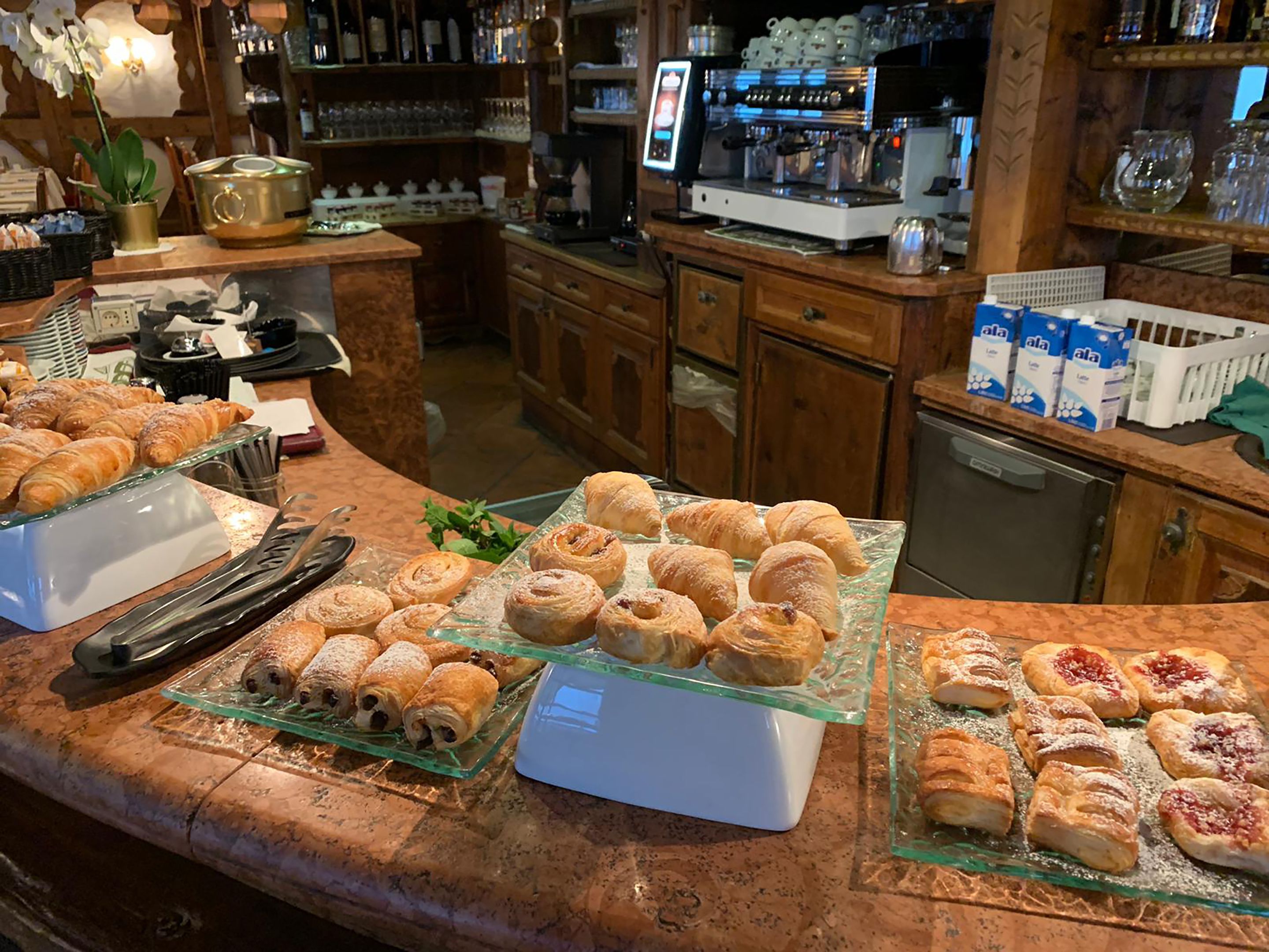 Un mostrador de panadería con diversos pasteles y una máquina de café.