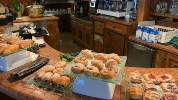 Un comptoir de boulangerie où sont exposées diverses pâtisseries, ainsi qu’une machine à café.