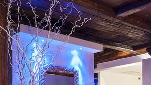 A modern interior with a large mirror, a tall vase, and two lanterns on the floor. - Hotel Querceto by Double Hospitality (Malcesine)