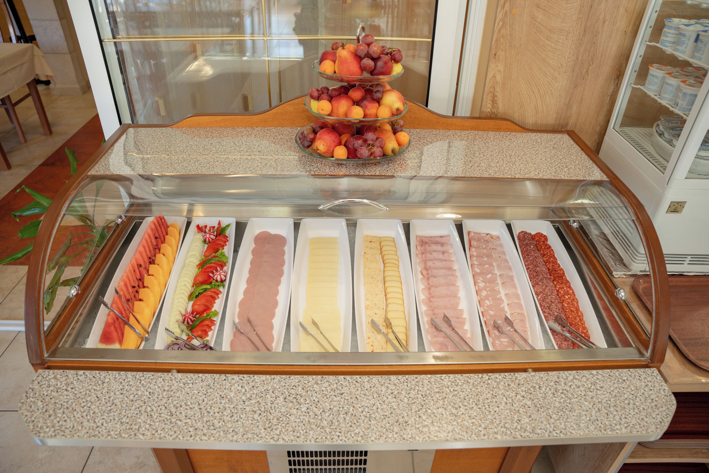 A buffet with various food items and a fruit display.