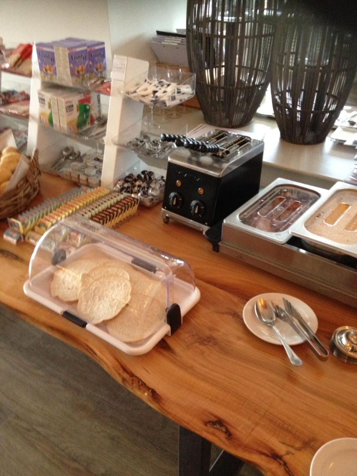 Una barra de desayuno con pan, bollería y un tostador.