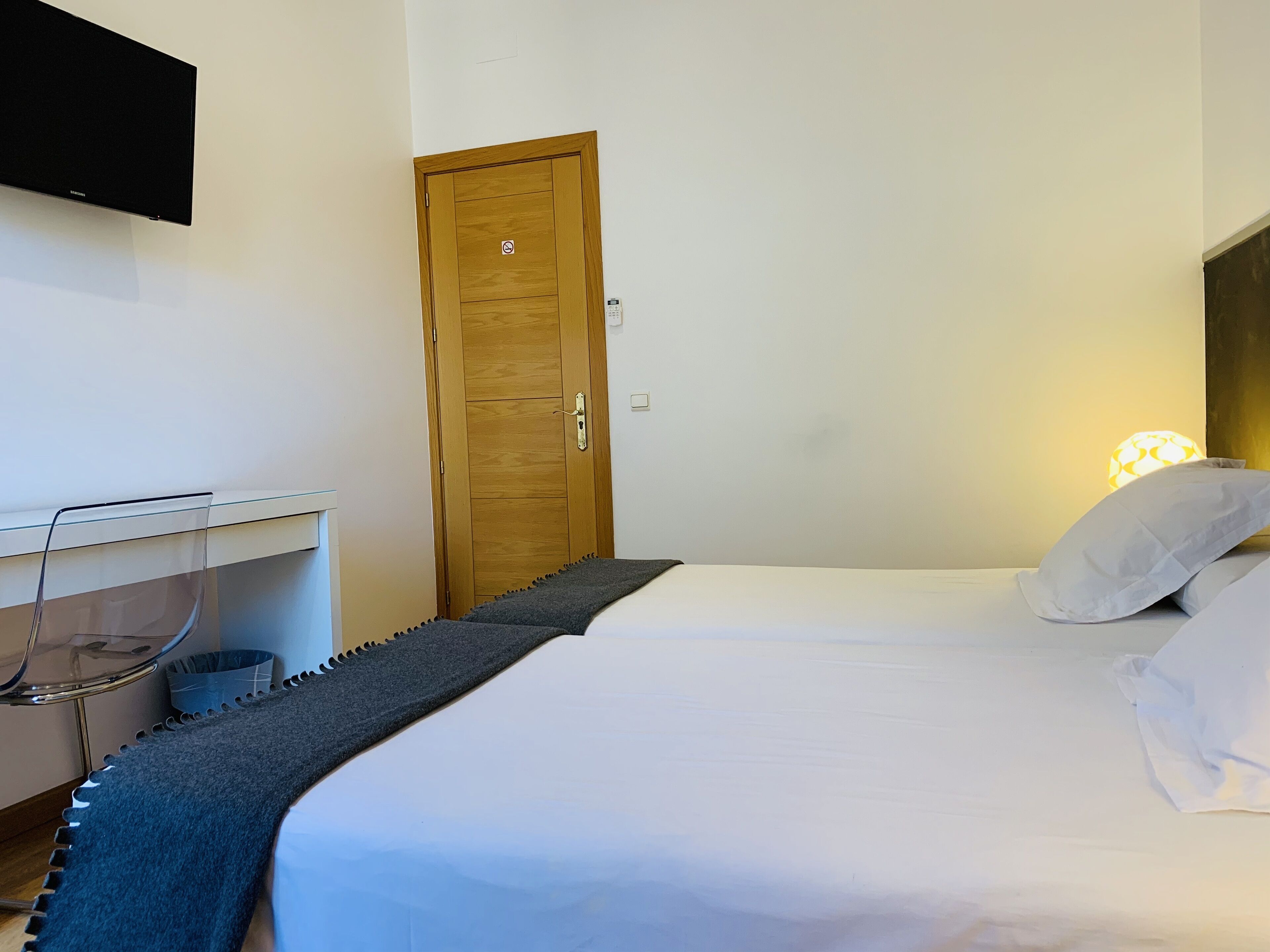 Una camera da letto con un letto, una scrivania e una porta.