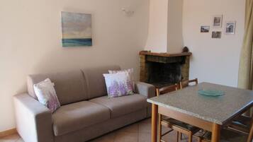A living room with a beige sofa, a wooden table, and a fireplace.