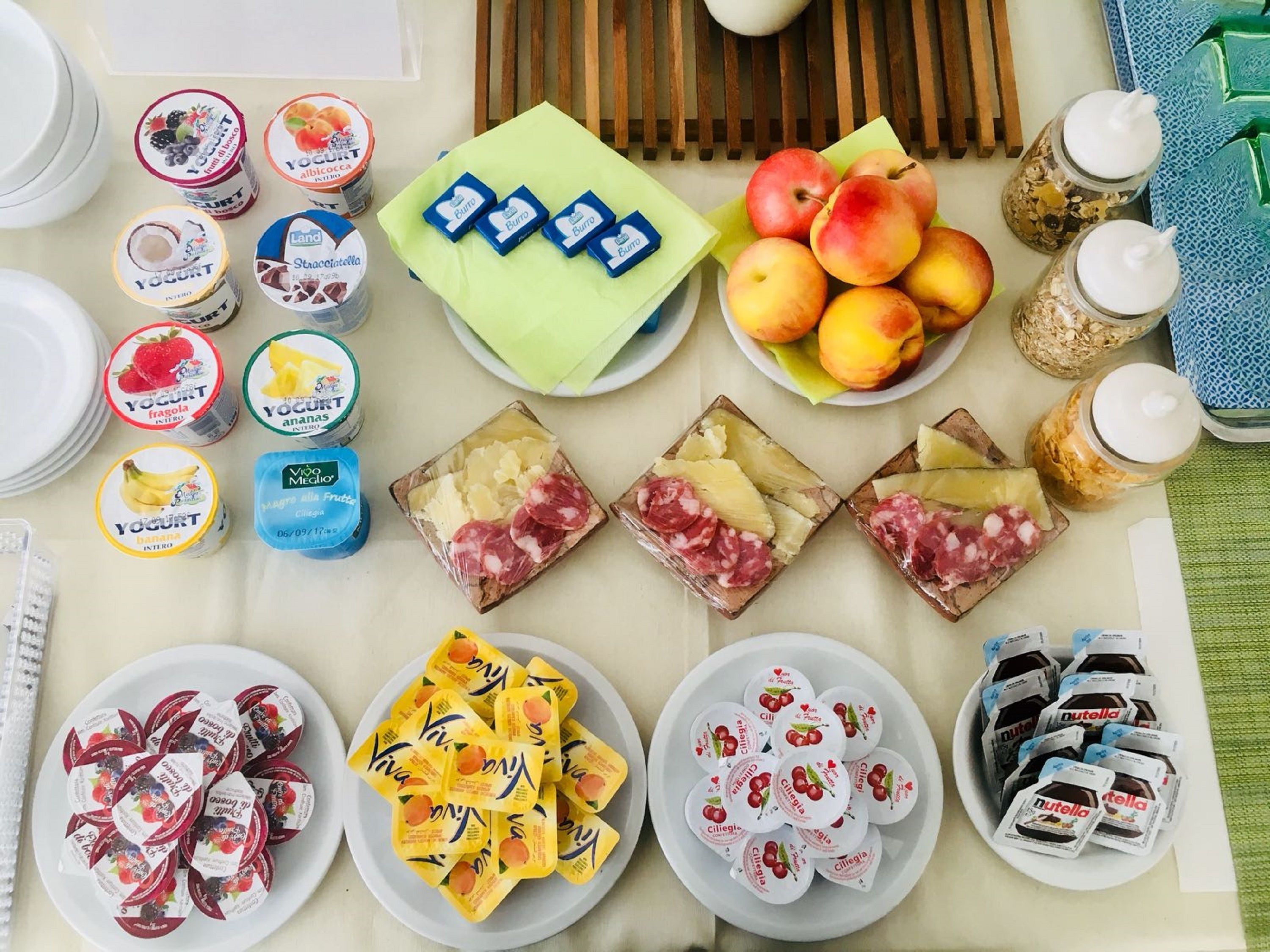 Une table sur laquelle on trouve divers aliments, notamment des yaourts, des fruits et des en-cas emballés.
