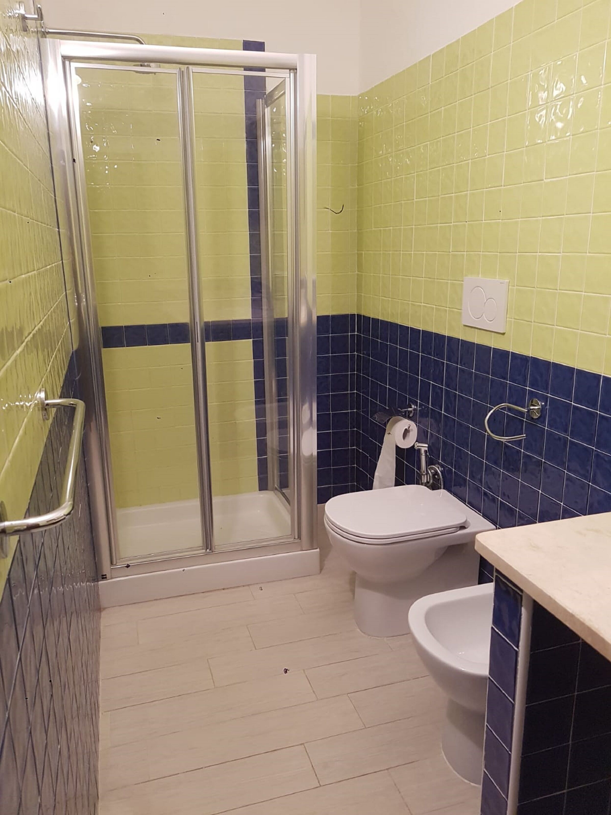 A bathroom with a glass-enclosed shower, a toilet, and a sink.