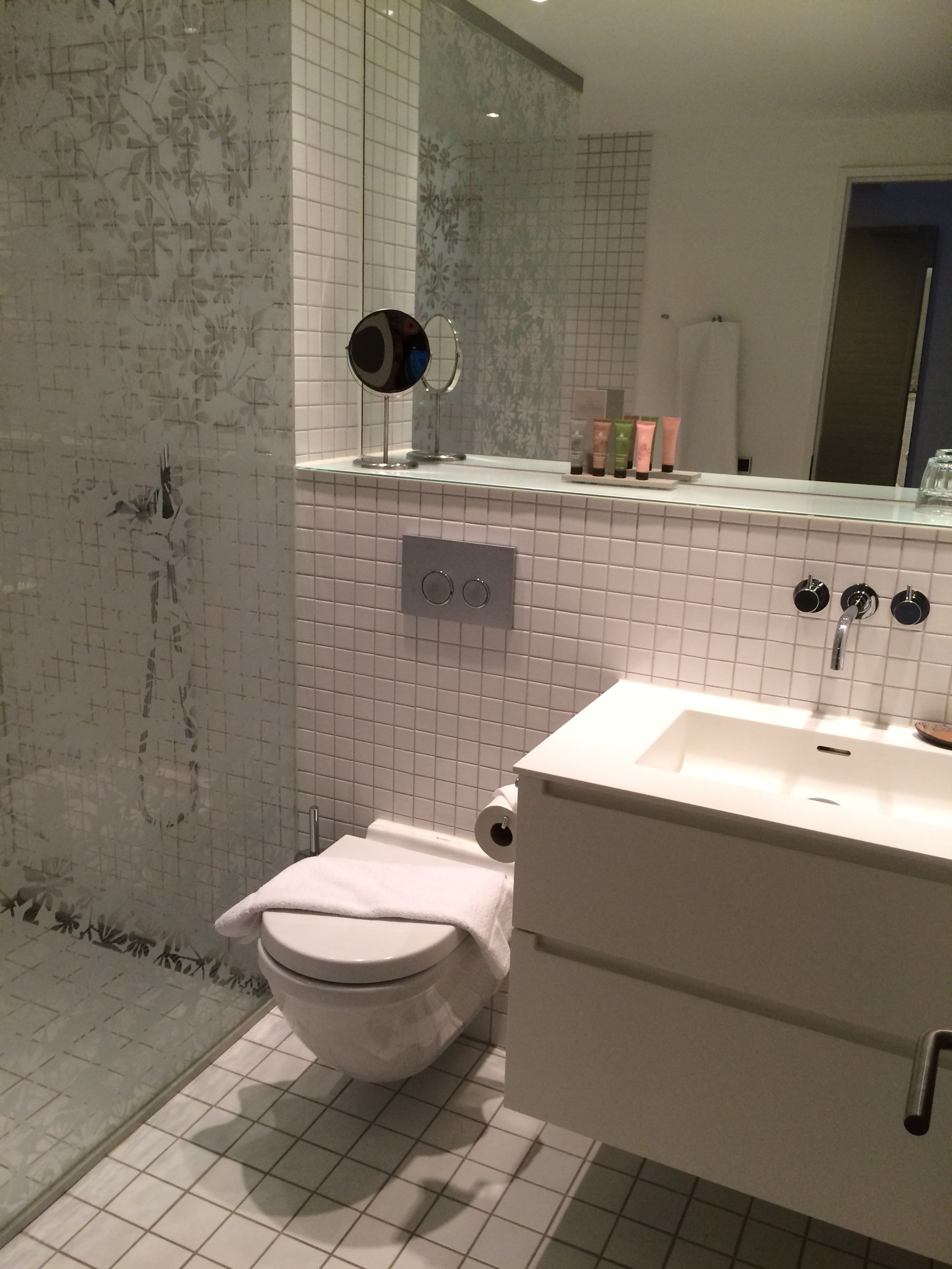 Un baño con inodoro, lavabo y espejo.