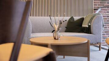 A modern interior with a sofa, a round wooden table, and a chair.