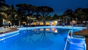A swimming pool with lounge chairs and a restaurant in the background. - Hotel Park Imperial (Forio)