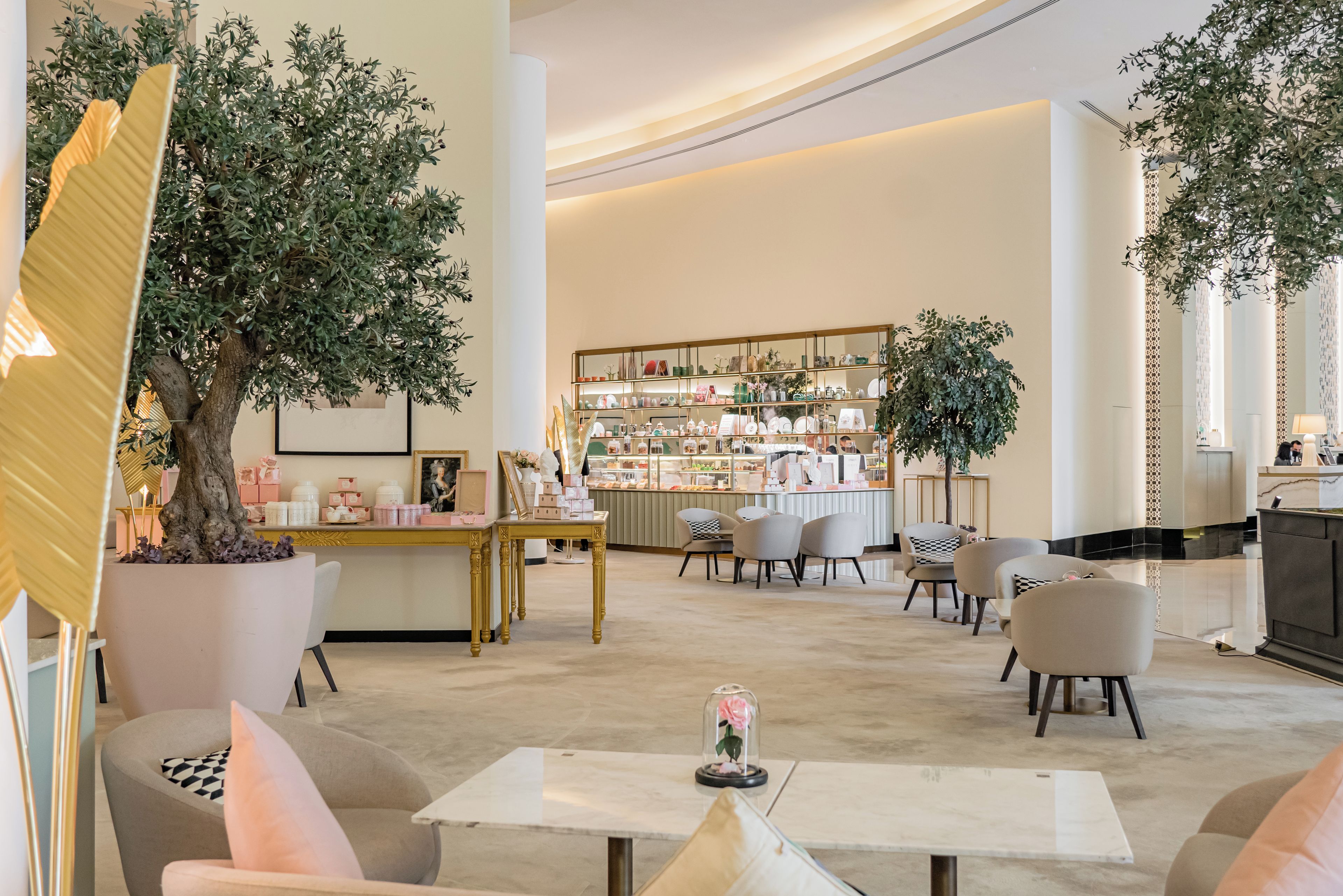 A spacious lobby with a reception desk, seating area, and a display of various items.