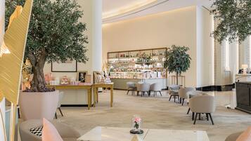 A spacious lobby with a reception desk, seating area, and a display of various items.