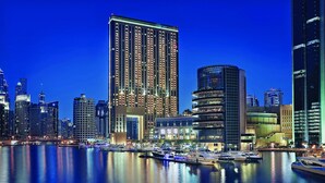 A city skyline with modern high-rise buildings and a marina with boats.