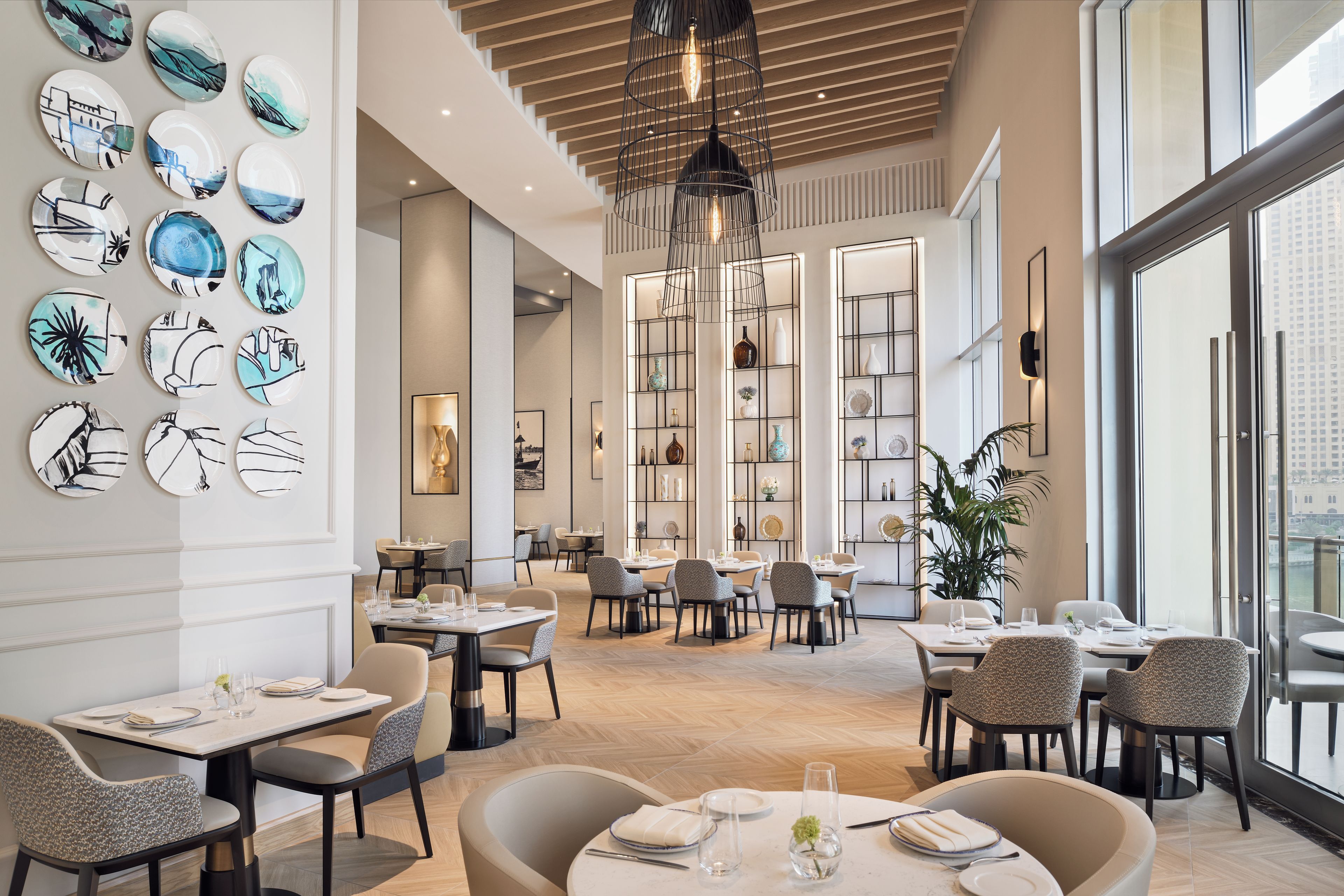 A modern dining area with round tables, chairs, and a variety of wall art.