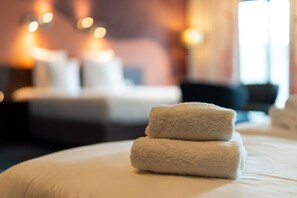 A neatly made bed with two folded towels in a hotel room. - Hampshire Delft Centre (Delft)