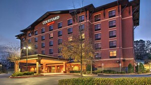 A Courtyard Marriott hotel with a brick facade, multiple floors, and a covered entrance area.