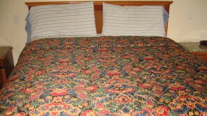 A bed with a colorful patterned bedspread and two pillows. - Walls Motel Long Beach (Long Beach)