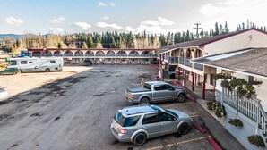 Un motel comprenant plusieurs chambres, un parking et un bâtiment doté d’un balcon.