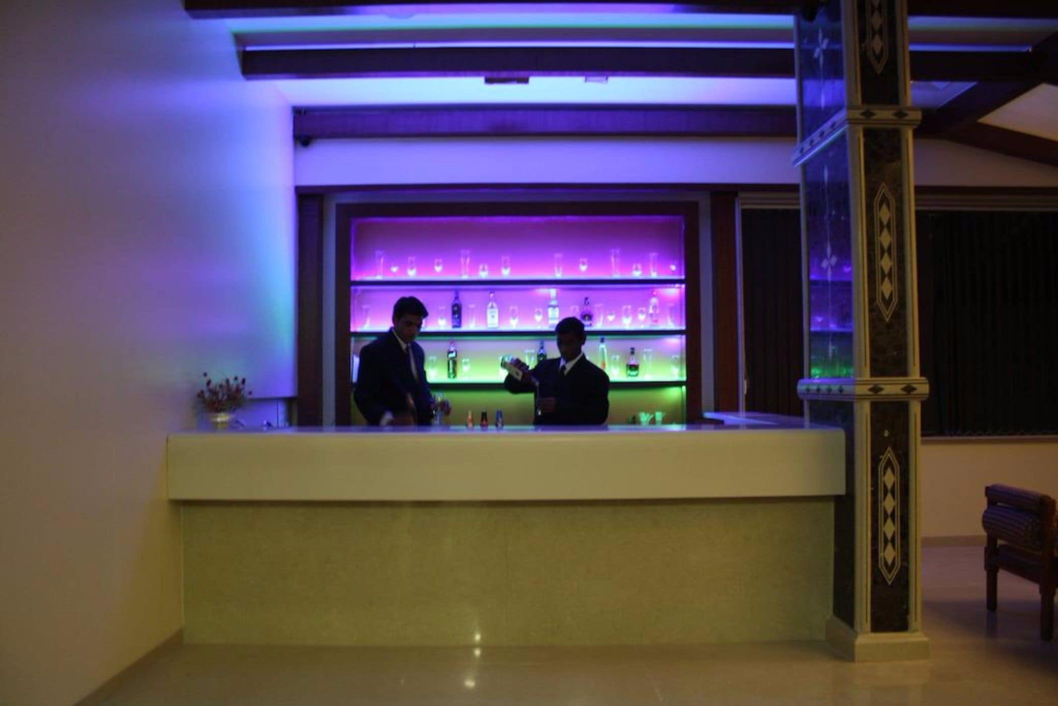 Zona de bar con mostrador y estanterías llenas de botellas.