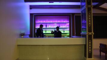 Zona de bar con mostrador y estanterías llenas de botellas.