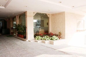 A hotel lobby with a patterned floor, a glass entrance, and potted plants. - The Fern Residency Aurangabad (Chhatrapati Sambhajinagar)