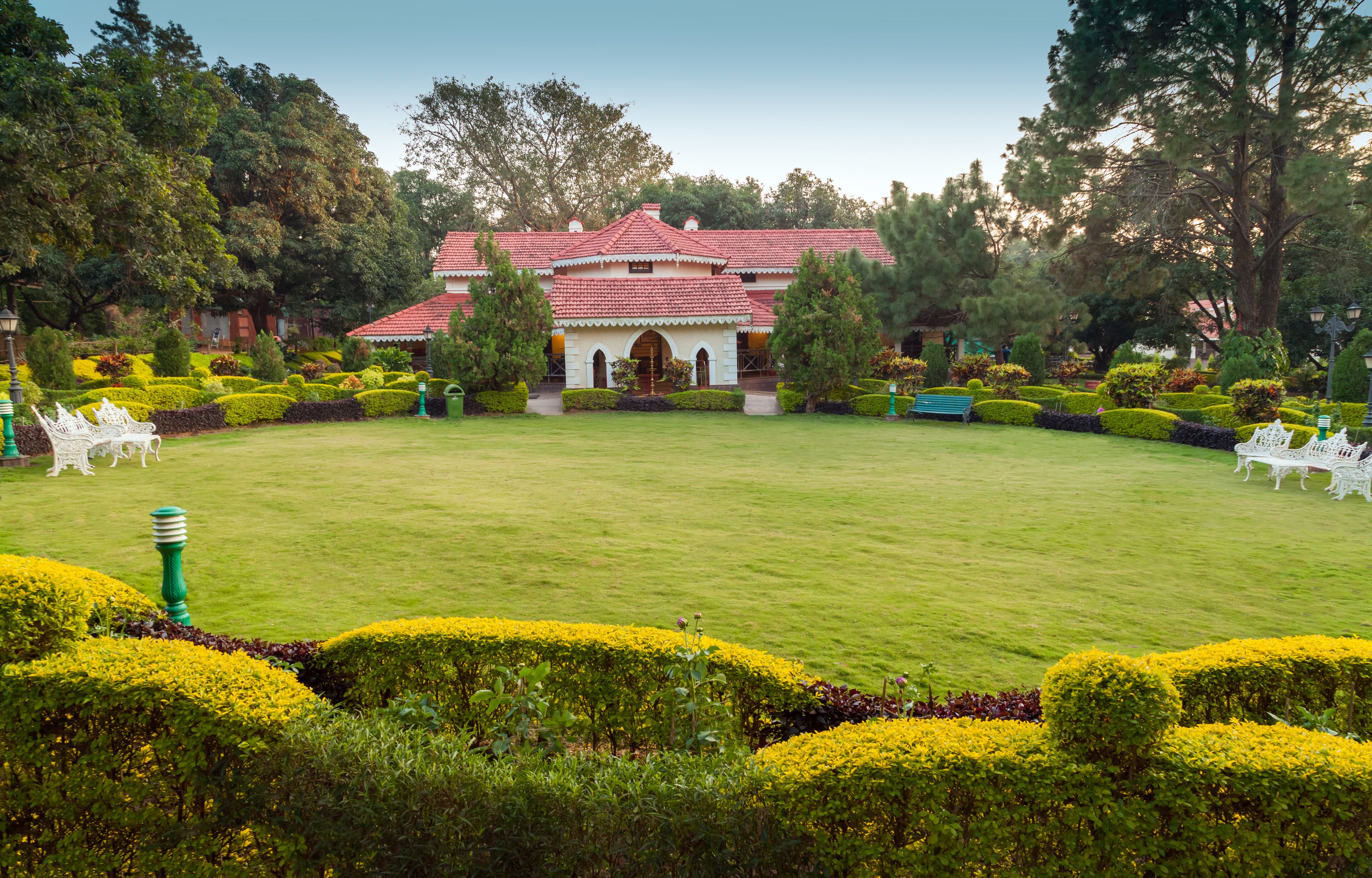A well-maintained garden with neatly trimmed hedges and a central lawn area.