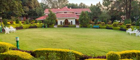 A well-maintained garden with neatly trimmed hedges and a central lawn area.