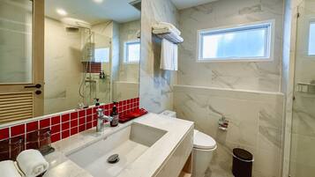 Un baño moderno con un lavamanos grande, inodoro, ducha y ventana.