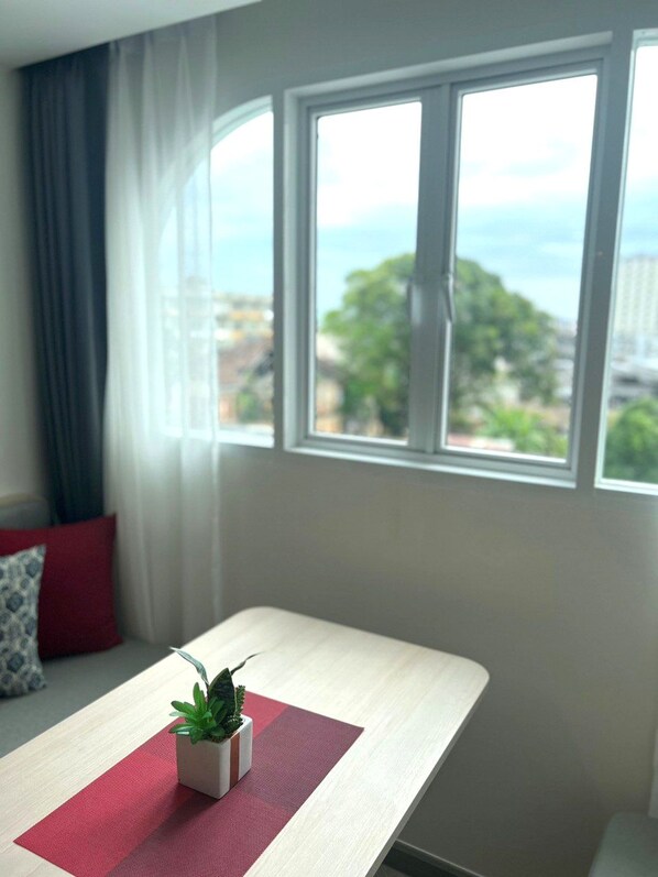 A room with a window, a small table, and a potted plant.