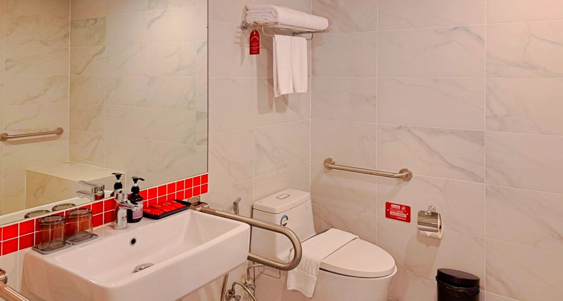 Un baño con lavamanos, espejo, inodoro y zona de ducha.
