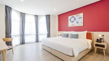 Ein modernes Hotelzimmer mit einem großen Bett, einem Schreibtisch und einem Sessel.