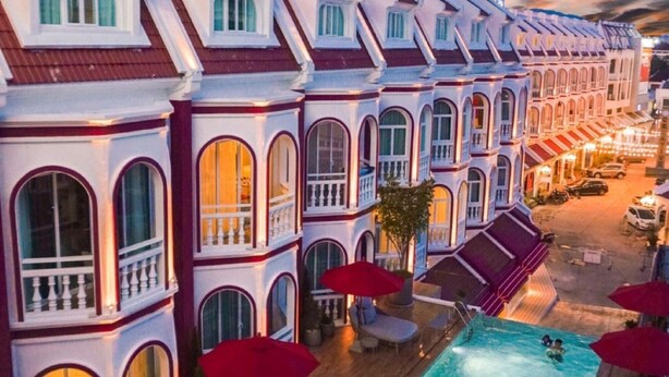 A hotel with a pool area, outdoor seating, and a view of the street. - Hotel Midtown Ratsada (Phuket)