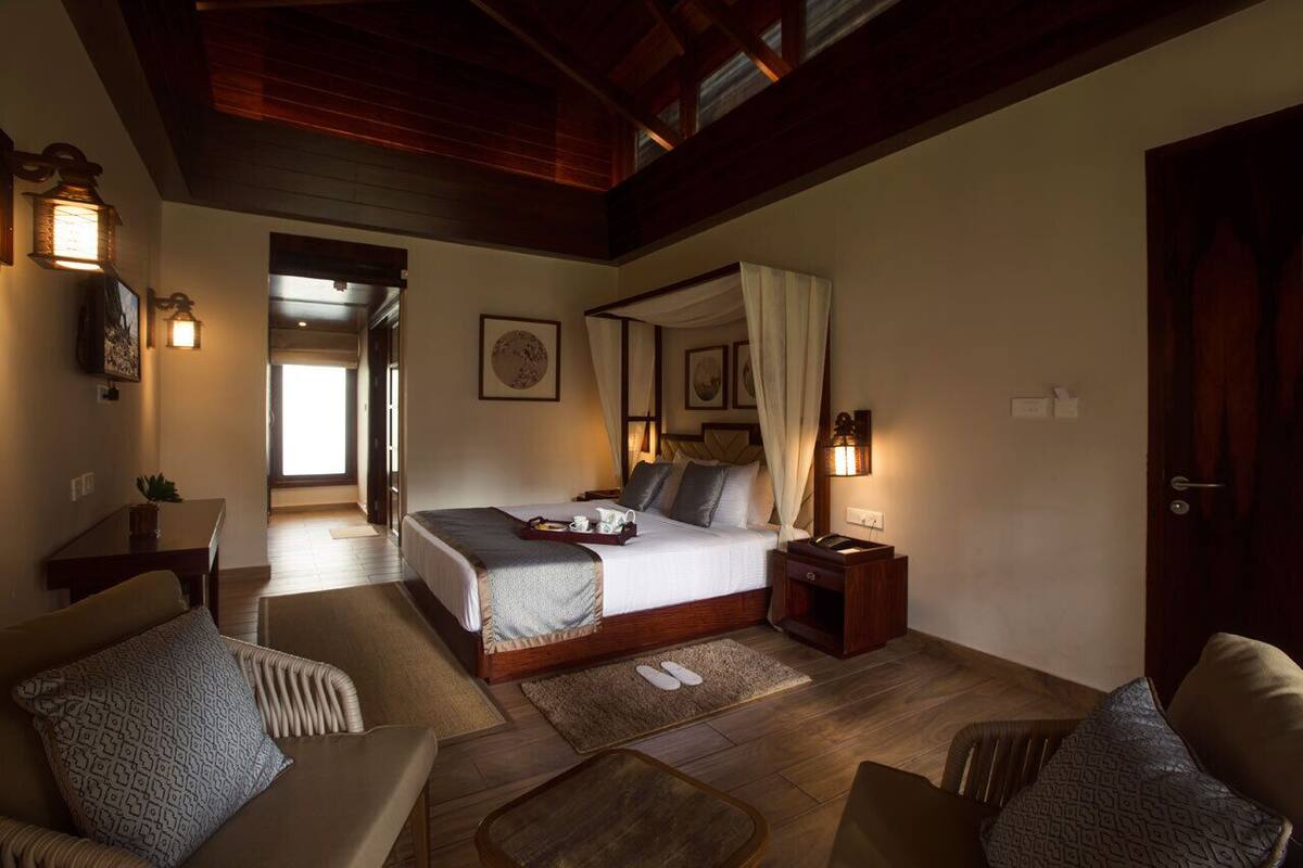 A bedroom with a large bed, bedside tables, a nightstand, and a view of a hallway.