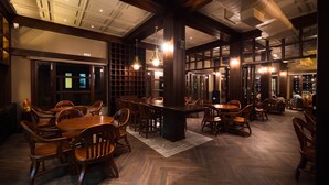 Un restaurante espacioso con mobiliario de madera y un techo alto.