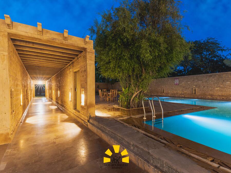 A pool area with a covered walkway and a stone wall.