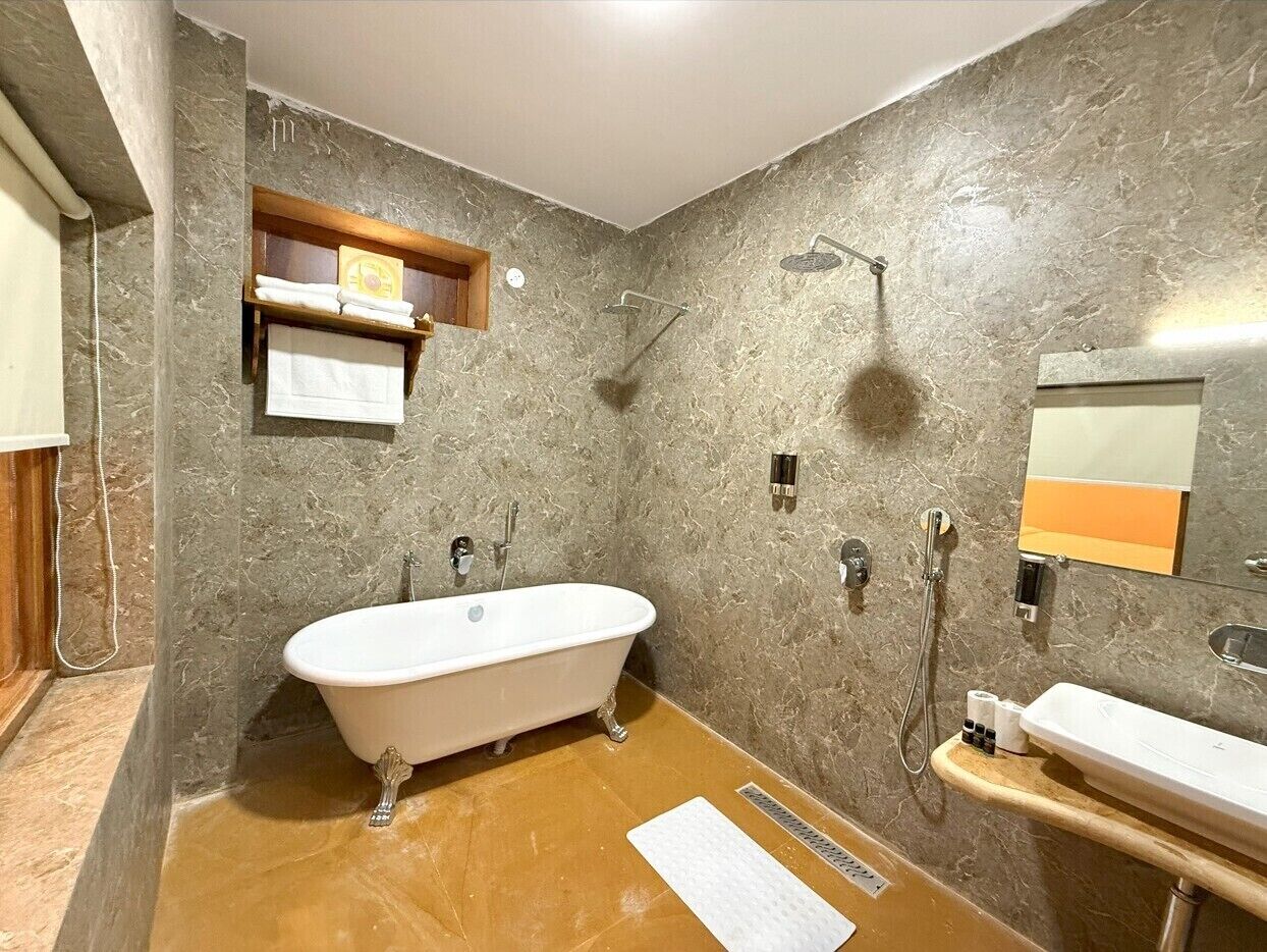 A bathroom with a freestanding bathtub, a vanity with a mirror, and a towel rack.