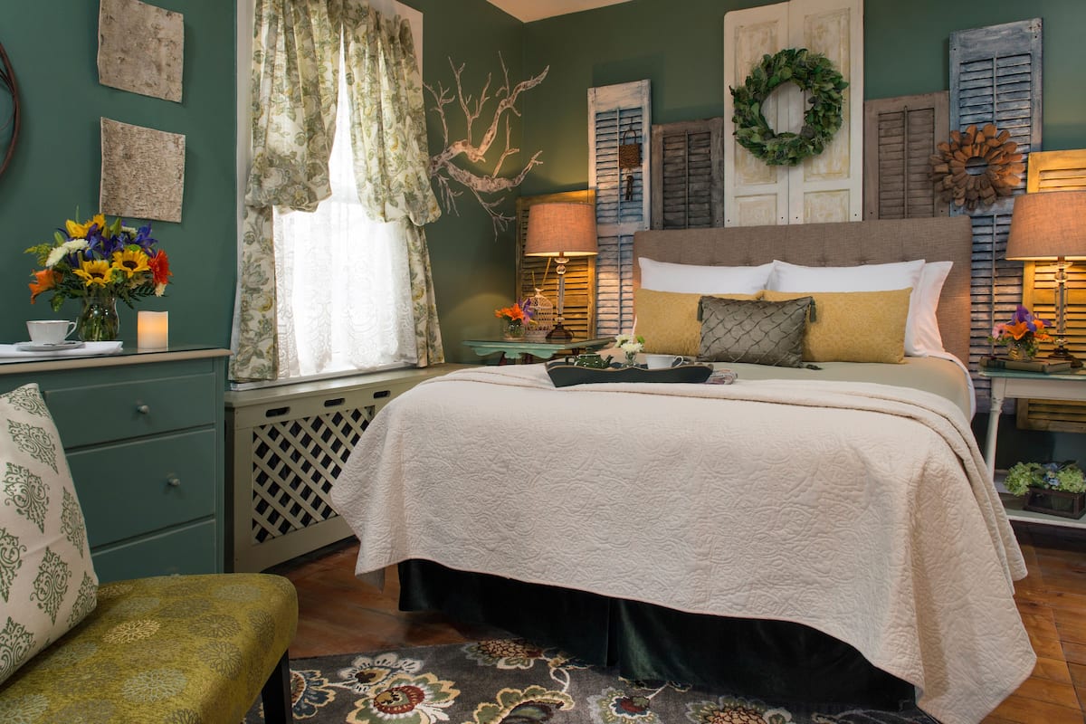 A bedroom with a bed, a nightstand, a dresser, and a chair.